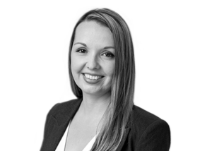 Black and white smiling woman in professional attire, black and white portrait.