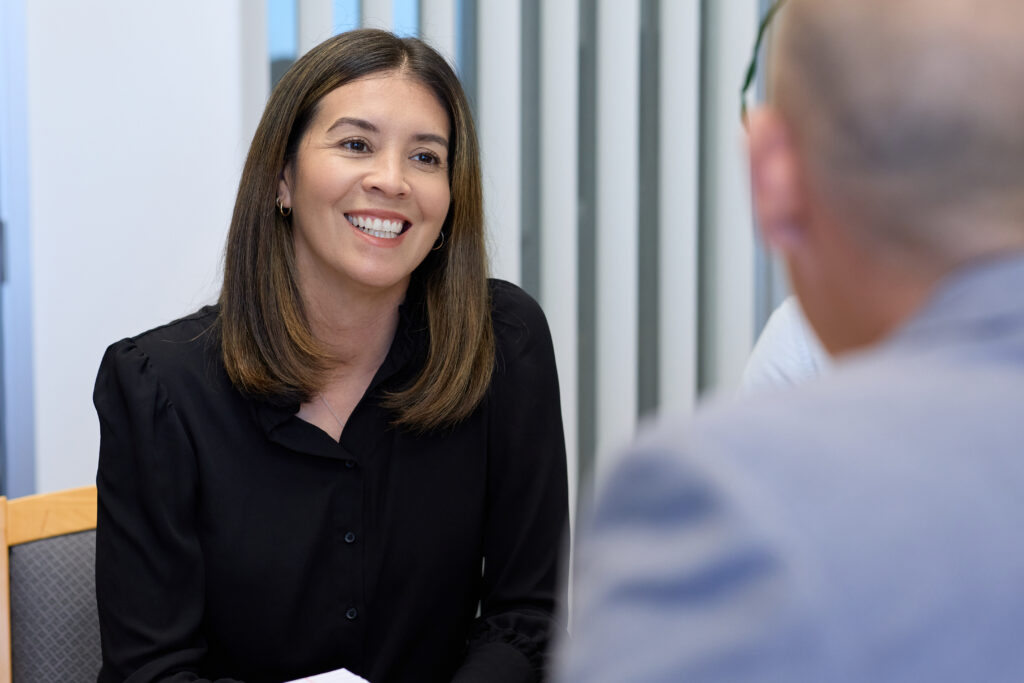 Smiling woman in business meeting, discussing project.