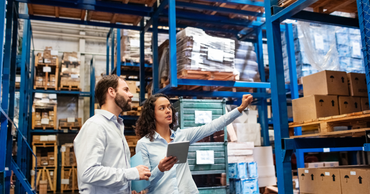 Warehouse workers discussing inventory with tablet