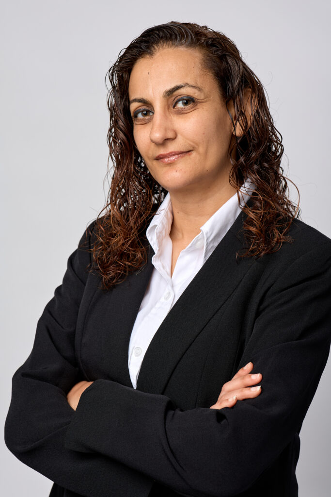 Confident woman in business attire with crossed arms.