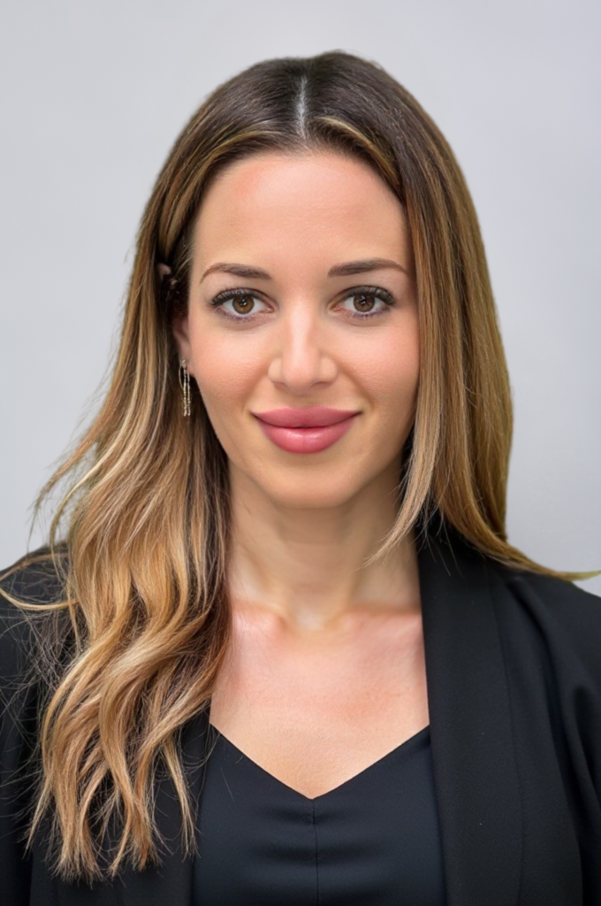 Smiling woman with long brown hair, black blazer.
