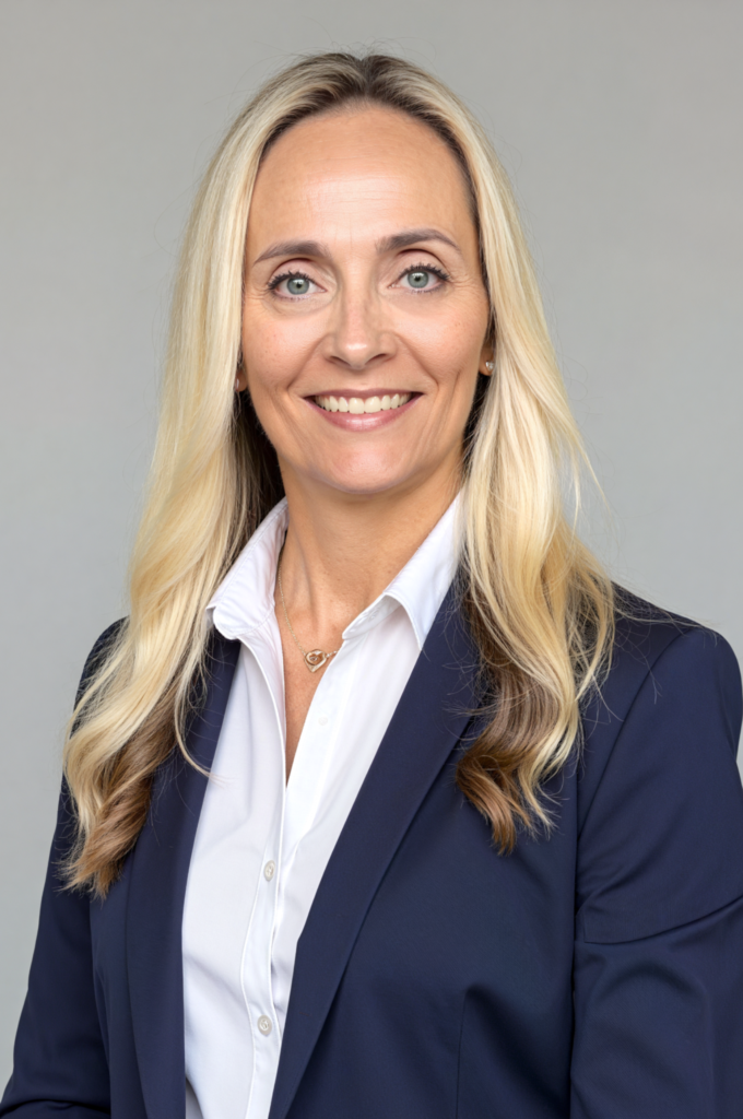 Smiling woman in professional attire posing confidently.
