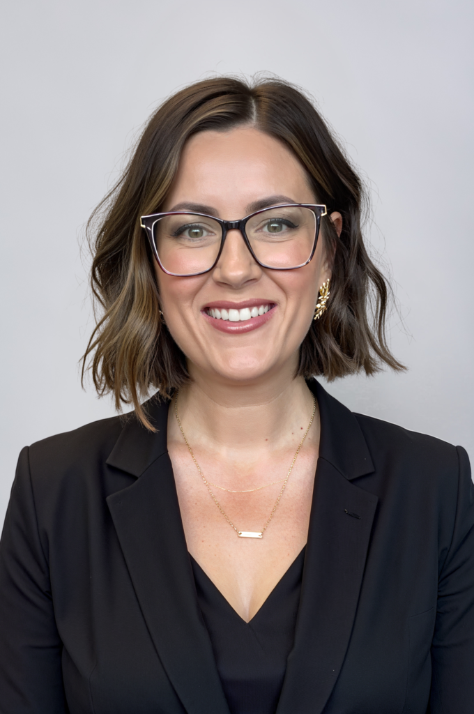 Smiling woman wearing glasses and black blazer